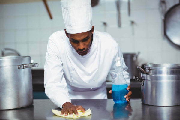 Chef using surface cleaner to make his kitchen cleaner