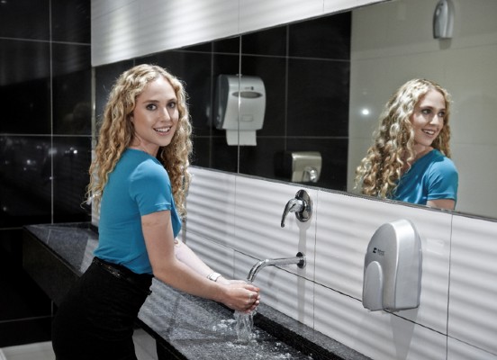 woman washing her hands with a Bidvest Steiner soap dispenser and paper towel dispenser